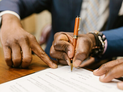 Close-up shot of a person signing a contract