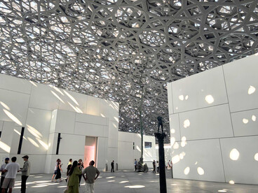 Les jeux d’ombre et de lumière du dôme du Louvre Abu Dhabi enveloppent les visiteurs, créant un dialogue unique entre architecture, nature et patrimoine universel