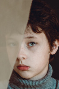 Menino olha fixamente para o nada enquanto viajava nos cenários criados em sua mente