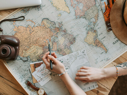 A traveler reviewing a world map and marking the countries she has been to