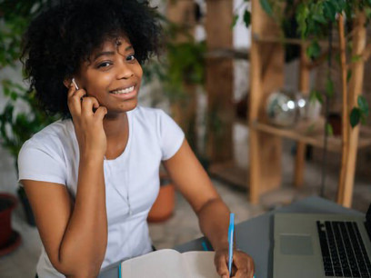 In a biophilic workspace, a female freelance designer creatively generates ideas, crafts a business plan, and works remotely on her laptop