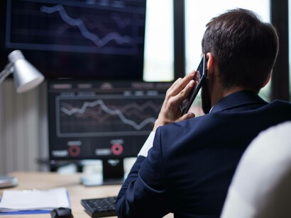 Uomo di fronte a grafici finanziari: "... superamento dell’economia del debito con cui l’umanità è stata dominata negli ultimi millenni; e della stessa moneta a debito...che è la base del potere finanziario e bancario"