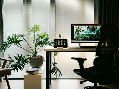 A bright, minimalist workspace with greenery and warm, cozy details