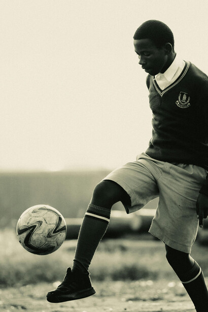 Athlete skillfully balancing a soccer ball with focus
