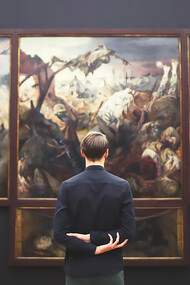 A man admiring a painting under expertly designed museum lighting in an art gallery, highlighting the impact of exhibition space illumination