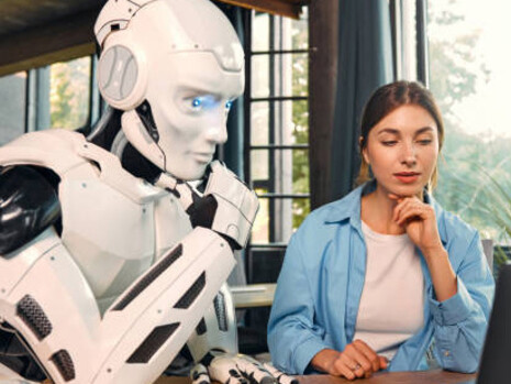 Human and AI working side by side at a laptop in an office, representing modern human–machine collaboration