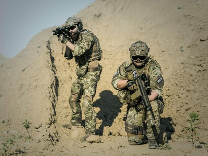 Heavily armed troops scanning hostile ground, embodying the transformation of counterterrorism into perpetual conflict management