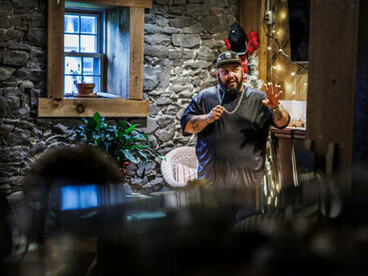 A Latino comedian performs a stand-up routine at a private country club