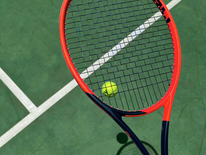 Raquette et balle sur le court : symboles immobiles d'un sport populaire dont Andre Agassi est devenu l'un des plus grands champions