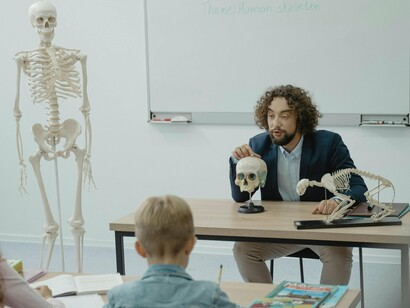 Professor ensina sobre o esqueleto humano à turma. Reforma na gestão escolar e valorização profissional: é necessário adotar uma administração mais colaborativa, na qual os professores participem das decisões e sejam reconhecidos não apenas simbolicamente, mas também financeiramente. O ajuste efetivo dos salários, com o cumprimento rigoroso do piso salarial, é crucial para a valorização dos educadores
 
