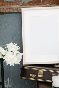 Quadro em branco sob caixa de violino e livros antigos