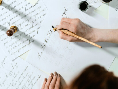 A hand writing gracefully, reflecting the love that grew stronger each time they chose to put pen to paper