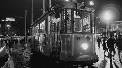 A red trolley car moves along a street in Istanbul, Türkiye, under the glow of the night