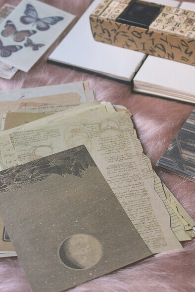 A warm, nostalgic flat lay of a vintage journal or scrapbook with aged, yellowed pages and delicate flowers resting on a wooden surface