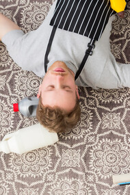 A tired man from cleaning the carpet, seen from above