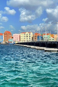 The vibrant waterfront of Willemstad’s Punda district—where Dutch colonial architecture meets Caribbean color—invites visitors to stroll, sip a Blue Lagoon, and watch history ripple across Santa Anna Bay