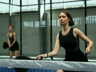 Elle est en train de jouer au padel il semble qu'elle va frapper fort 