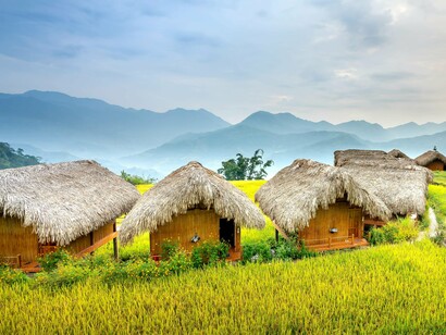 Bamboo huts framed by nature, symbolizing housing solutions that prioritize sustainability over excess