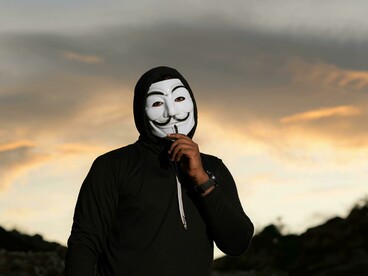 Man wearing a Guy Fawkes mask during a protest or riot