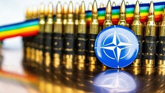 A NATO pin badge in front of bullets, representing the military alliance between member countries to promote peace and security 
