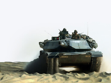 An M-1A1 Abrams main battle tank travels with a military convoy along a desert road during Operation Desert Shield