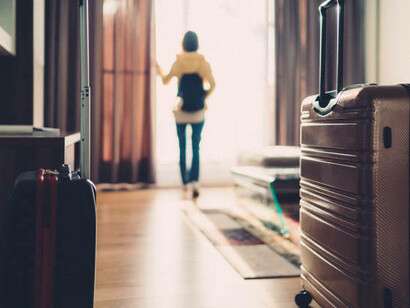 A woman traveling alone walks into her hotel room