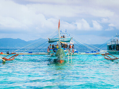 Outrigger boat surrounded by endless blue waters, reflecting stories carried across restless waves