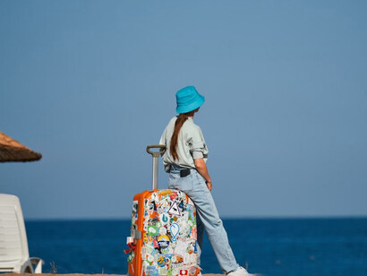 A woman on a beach with a suitcase, embodying the spirit of a digital nomad and the freedom to work from anywhere
