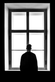 Homem contemplando janela. A demarcação emocional é uma metáfora que nos convida a explorar os territórios internos da mente