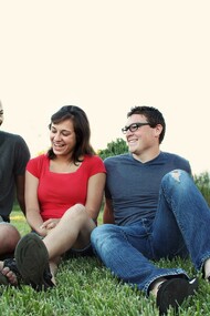 A group of platonic friends sat on the grass talking to each other 
