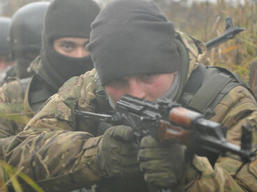 Ukrainian soldiers from the 1st Battalion take position inside a frontline trench