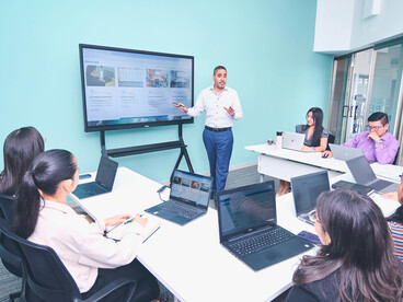 A business presentation taking place in a modern office environment with a focus on professional development and business training