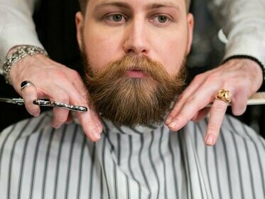 Barbeiro apara a barba de seu cliente. Historiadores como Anthony Birley interpretam este gesto como política cultural deliberada: através da barba, Adriano materializava sua orientação filohelênica enquanto reformava instituições latinas