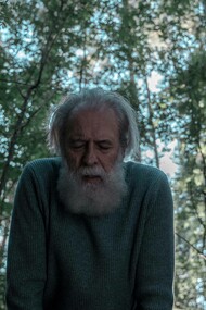 An ageing man in the forest trying to catch his breath