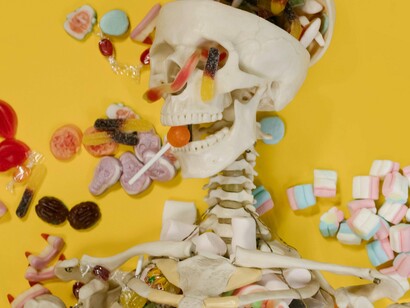 Esqueleto cercado de doces. Eu nunca consegui entender o fato de algumas pessoas insistirem em ver o açúcar como um calmante, talvez você já tenha se deparado com a seguinte situação: O sujeito passa mal, e logo se ouve alguém a declarar; dá-lhe um copo de água com açúcar que ele se recupera… Incrível!