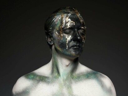 A figure marked by overlapping textures and colours, showcasing the many emotional layers often denied to male character