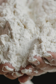Mãos preparam um alimento à base de farinha de trigo