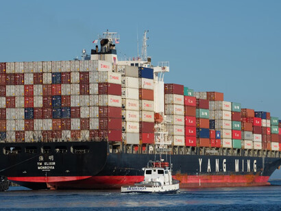 Cargo ships docked at the pier during the day, with freight containers on board, highlighting global trade, strategic partnerships, and the India-Middle East-Europe Economic Corridor within the context of economic diplomacy