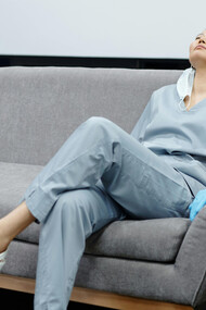 Enfermeira exausta em sofá de hospital tenta descansar a mente por alguns minutos no intervalo de sua jornada de trabalho na área da saúde