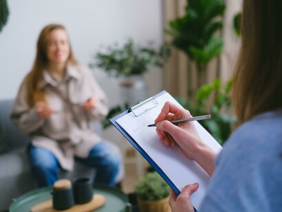 Mental health therapy session with a psychologist documenting observations and treatment progress