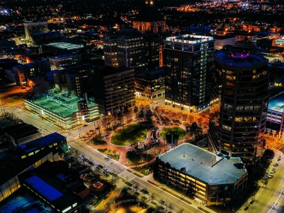 Artificial light floods the skyline, mirroring a civilization bright with consumption but dim in reflection