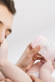 Un padre dando el biberón a su bebé