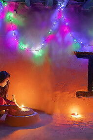 Nepalese sister lighting traditional lamp during Tihar festival, Nepal