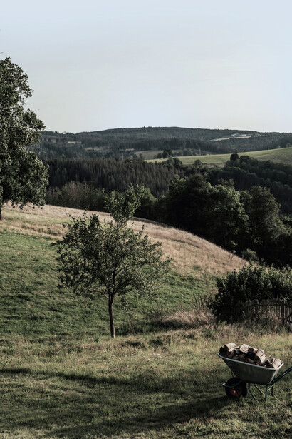 A couple sitting on a bench in a green countryside landscape on the moors