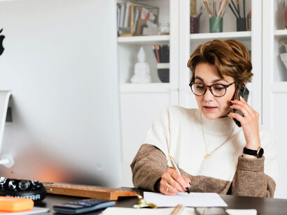 A woman navigating multiple responsibilities during a work call, illustrating how modern work habits can divide a leader’s attention