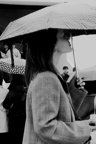 Admiradores, estilistas e estudantes reunidos em frente a entrada de um desfile de moda