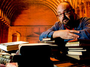 Carlos Ruiz Zafón apoiado sob livros 