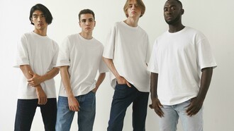 Men posing in classic white T-shirts and jeans against a minimalist backdrop