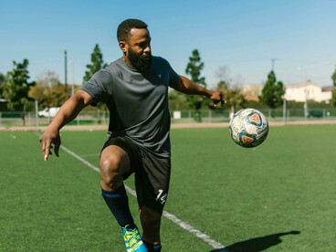 Soccer playing kicks the ball underlining focus and discipline 