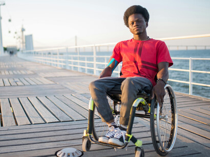 In a wheelchair, a man with Afro hair reflects the journey of transformation—marked by self-discovery, growth, and healing